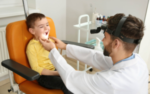 Otolaryngology doctor looking inside childs mouth