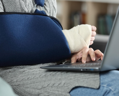 Image of an injured patient using a computer to check their medical records.