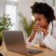 Image of a stressed medical professional looking at their laptop.