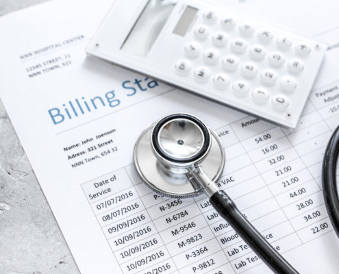 medical treatmant billing statement with stethoscope and calculator on stone background